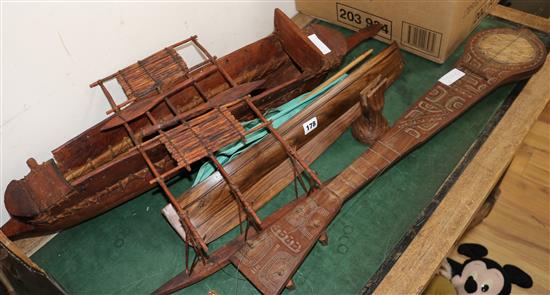 Two wooden models of boats and a carved four string instrument largest boat 86cm
